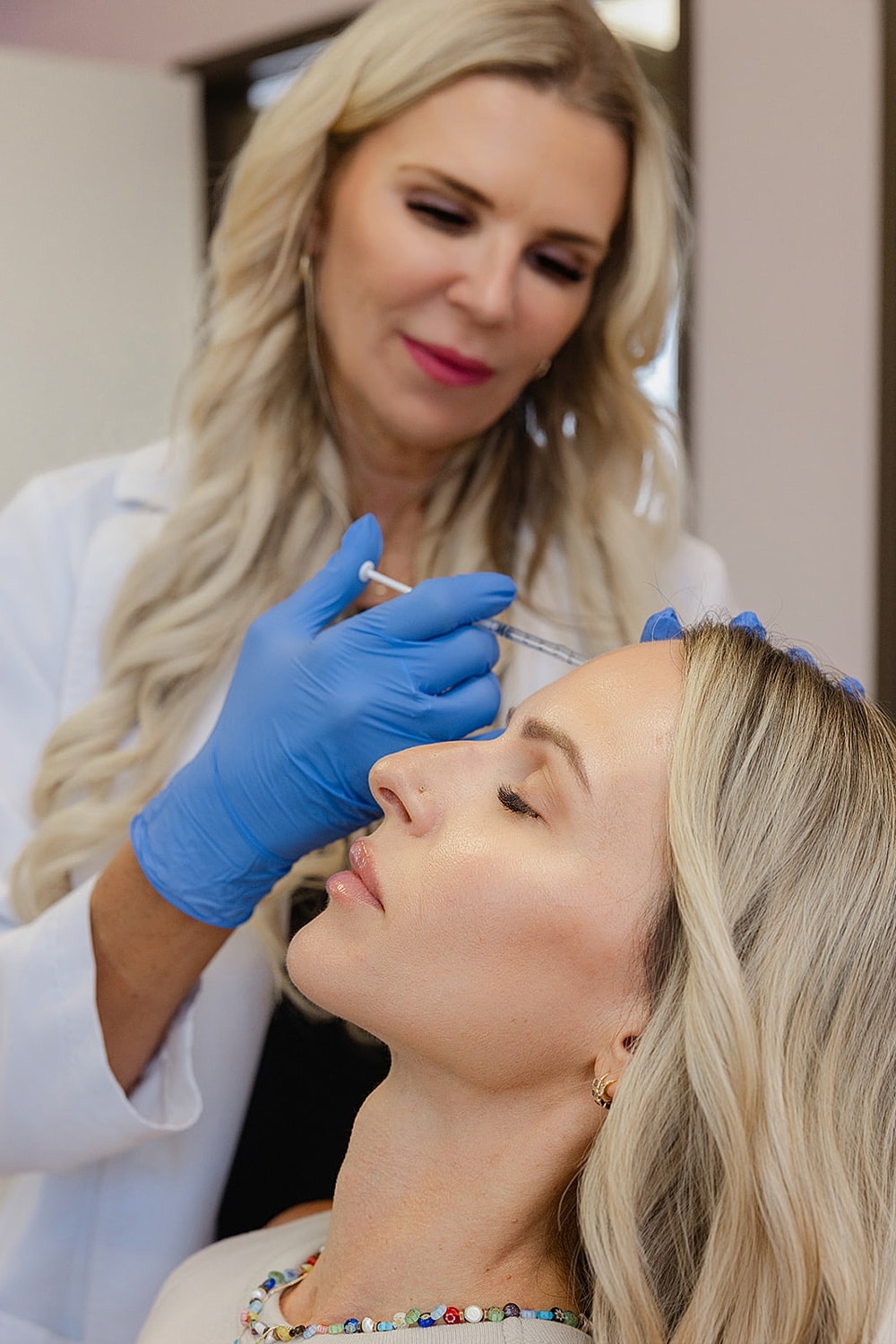 Woman receiving beauty treatment in clinic.
