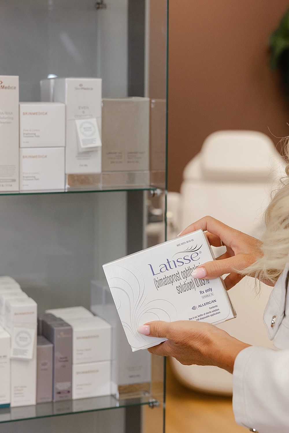Person holding Latisse lash enhancement solution box.
