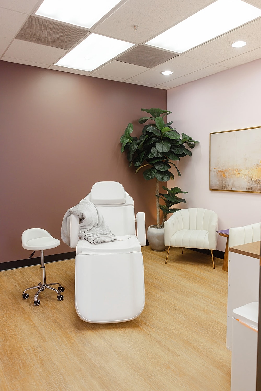 Modern aesthetic treatment room with white furniture.